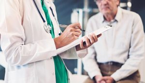 Doctor documenting in chart using 2021 E/M changes in primary care