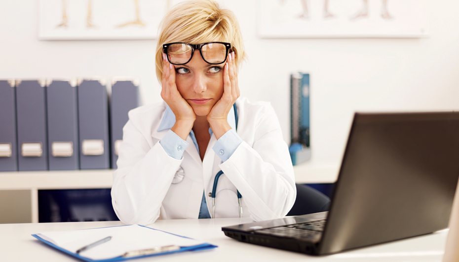 Frustrated healthcare worker seated at desk
