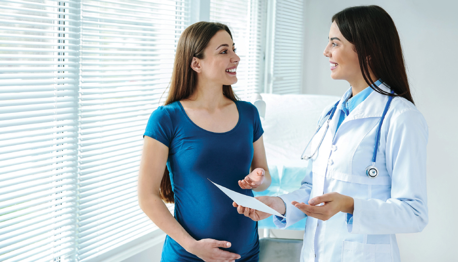 Pregnant patient reviewing insurance with doctor