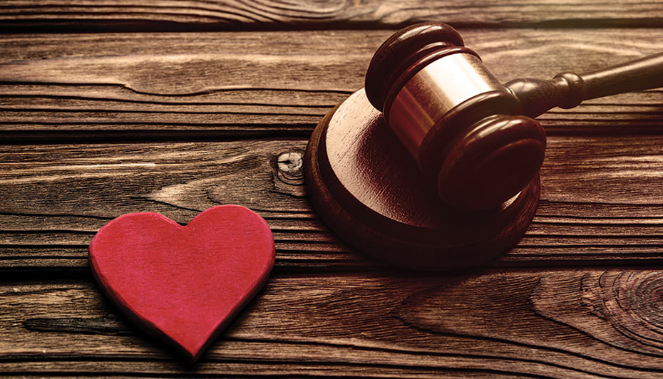 Gavel on table with red heart.